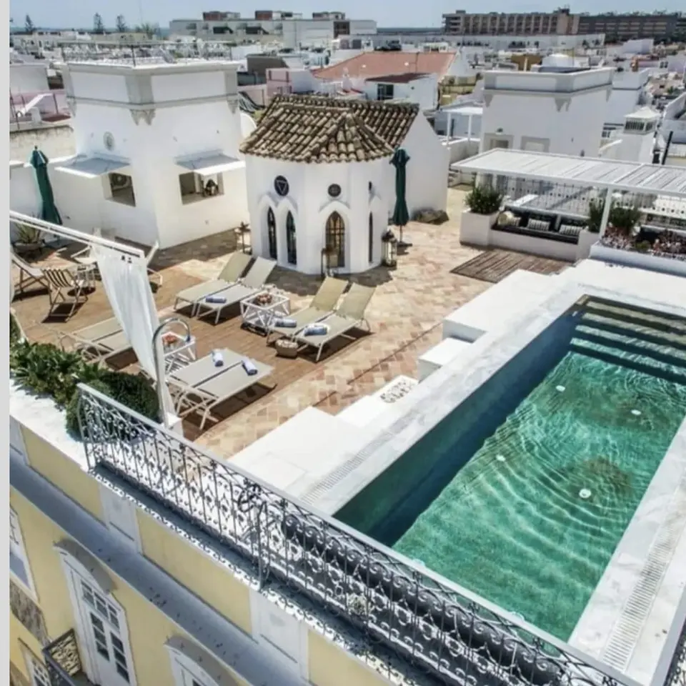 Vista aérea do terraço com piscina, deck e torreão sobre os telhados de Olhão