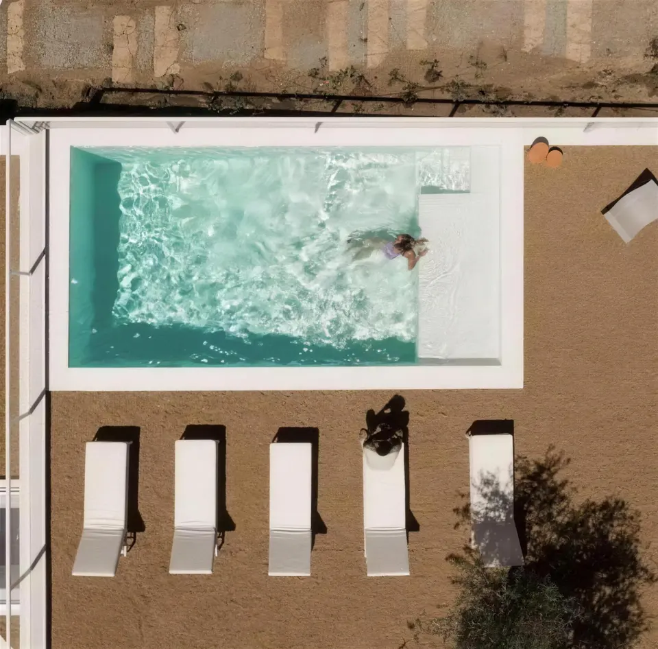 Vista aérea de piscina turquesa com espreguiçadeiras